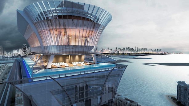 A modern architectural building with a unique curved design, featuring a rooftop swimming pool and lounge area. - Palm Tower Palm Jumeirah By DVH Luxe (Dubai)
