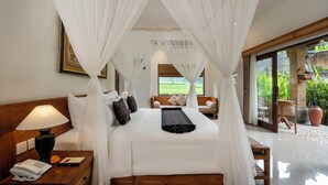 A bedroom with a canopy bed, a bedside lamp, a telephone, and a view of the garden through the window. - Govala Ubud Villa & Spa (Tegallalang)