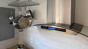 A kitchen with a stainless steel range hood, hanging pots, and a modern backsplash. - Fabulous 5-bedroom chalet in charming Wilmington perfect for groups (Wilmington)