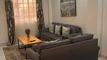 Deluxe-Apartment, Gartenblick | Wohnbereich | 32-Zoll-Smart-TV mit Digitalempfang