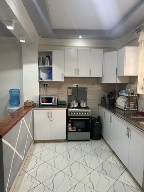 Deluxe Apartment, Garden View | Private kitchen | Fridge, microwave, cookware/dishes/utensils - Koselig Homes califonia Plaza Nanyuki (Nanyuki)