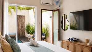 A hotel room with a bed, a TV, a wooden cabinet, and a view of the outdoors. - EveEvy Private Pool Villas (Lembongan Island)