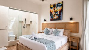 A modern bedroom with a large bed, a glass shower enclosure, a painting on the wall, and a wooden floor. - EveEvy Private Pool Villas (Lembongan Island)