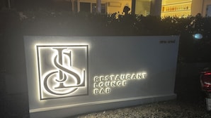 Placa para um bar lounge restaurante, com logotipo estilizado e texto iluminado.