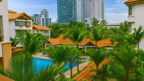Een resort met een zwembad, omringd door palmbomen en gebouwen met oranje daken.