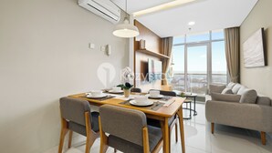 Ein modernes Wohnzimmer mit Essbereich, einer Couch und einem großen Fenster mit Blick auf die Stadt.