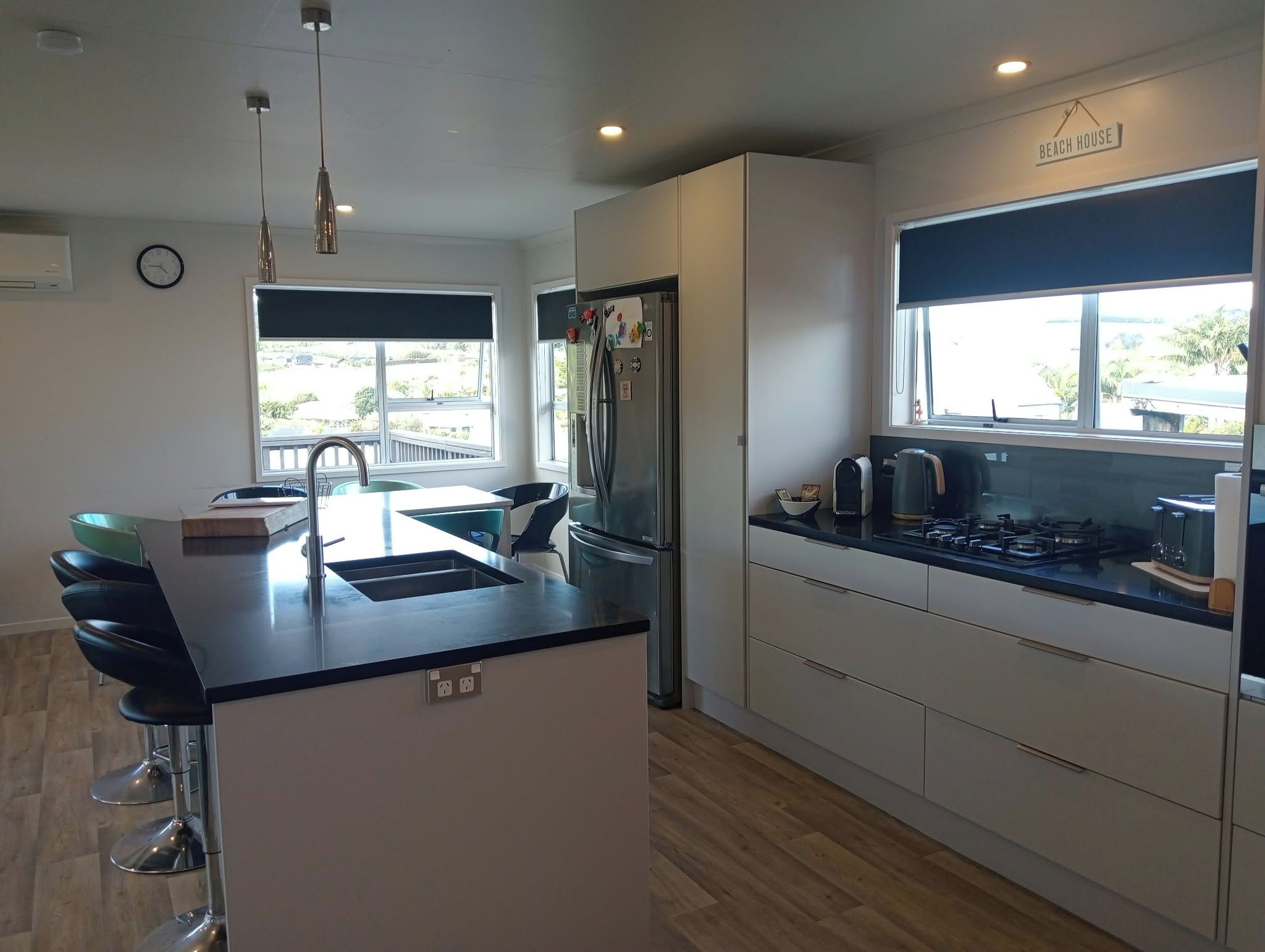 A modern kitchen with a central island, a built-in oven, and a window overlooking a balcony.