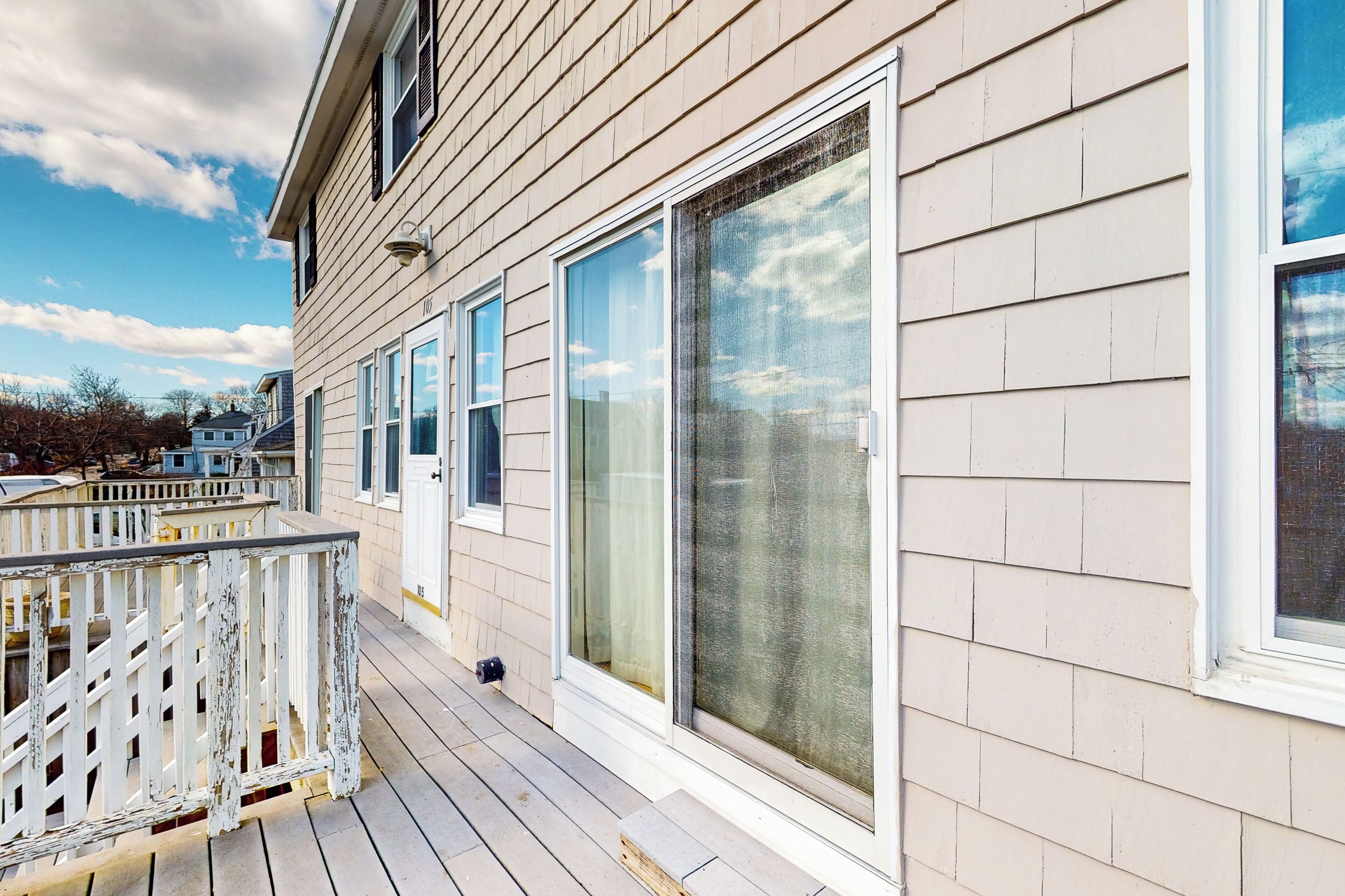 Une maison avec une terrasse en bois et de grandes fenêtres.