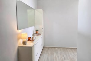 A modern bathroom with a white vanity, a mirror, a small potted plant, and a candle. - Sea Vista Durres 50m from beach, Durres, Albania (Durres)