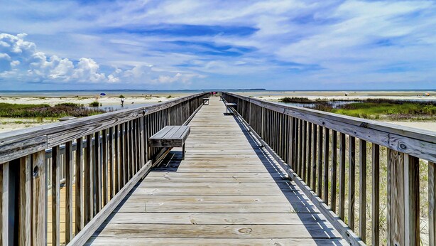 A wooden boardwalk leading to a beach with a bench and railing. - Hilton Head Haven: Beach House Lookout w/ Pool (Hilton Head Island)