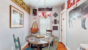 A dining area with a round table, chairs, a chandelier, and wall decorations including a sign that says "FAMILY". - Cozy Cottage w/ Hot Tub in Freeland, Pets Welcome! (Freeland)