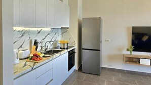 Een koffiezetapparaat/waterkoker, een koelkast, een oven, een kookplaat