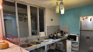 Uma cozinha com bancada de mármore, eletrodomésticos de aço inoxidável e parede azul.