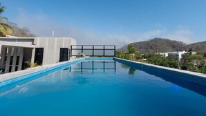 Una piscina con un cielo azzurro limpido e montagne sullo sfondo.