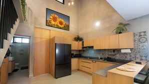 Una cucina moderna con mobili in legno, un frigorifero nero e uno schienale rivestito di piastrelle.
