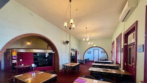 A restaurant with brick arches, wooden tables, and hanging chandeliers. - Royal Exchange Hotel Burra (Burra)