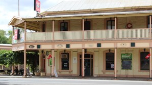 A two-story building with a balcony, multiple windows, and signs indicating various businesses. - Royal Exchange Hotel Burra (Burra)