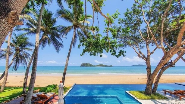 A poolside area with lounge chairs and a view of the beach. - the nest private beach resort (Chumphon)