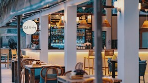 A restaurant with a bar area, wooden furniture, and hanging pendant lights. - the nest private beach resort (Chumphon)