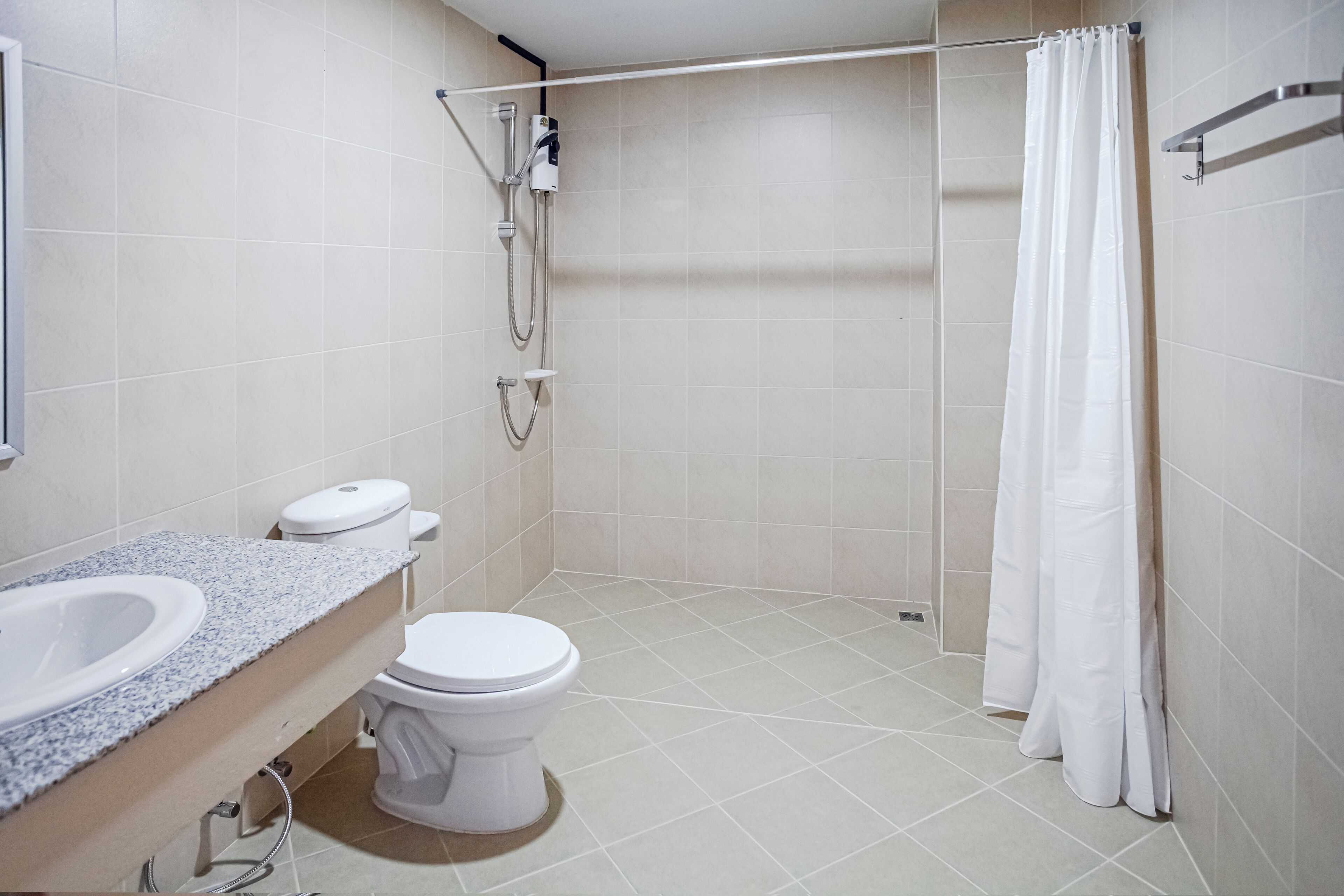 Een badkamer met een wit toilet, een wastafel en een douche met gordijn.