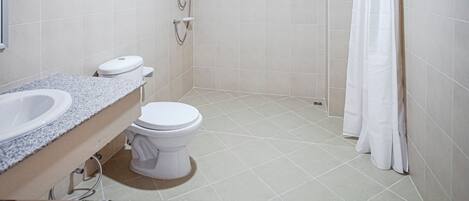 A bathroom with a white toilet, a sink, and a shower area with a curtain.