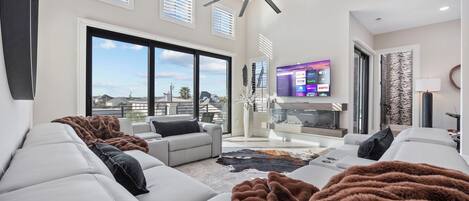 Una Smart TV, una chimenea, libros, una pantalla de ordenador