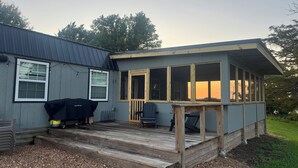 A house with a covered porch, a barbecue grill, and a deck. - Cozy, lakeside tiny home in Arkansas farm country (Parkin)