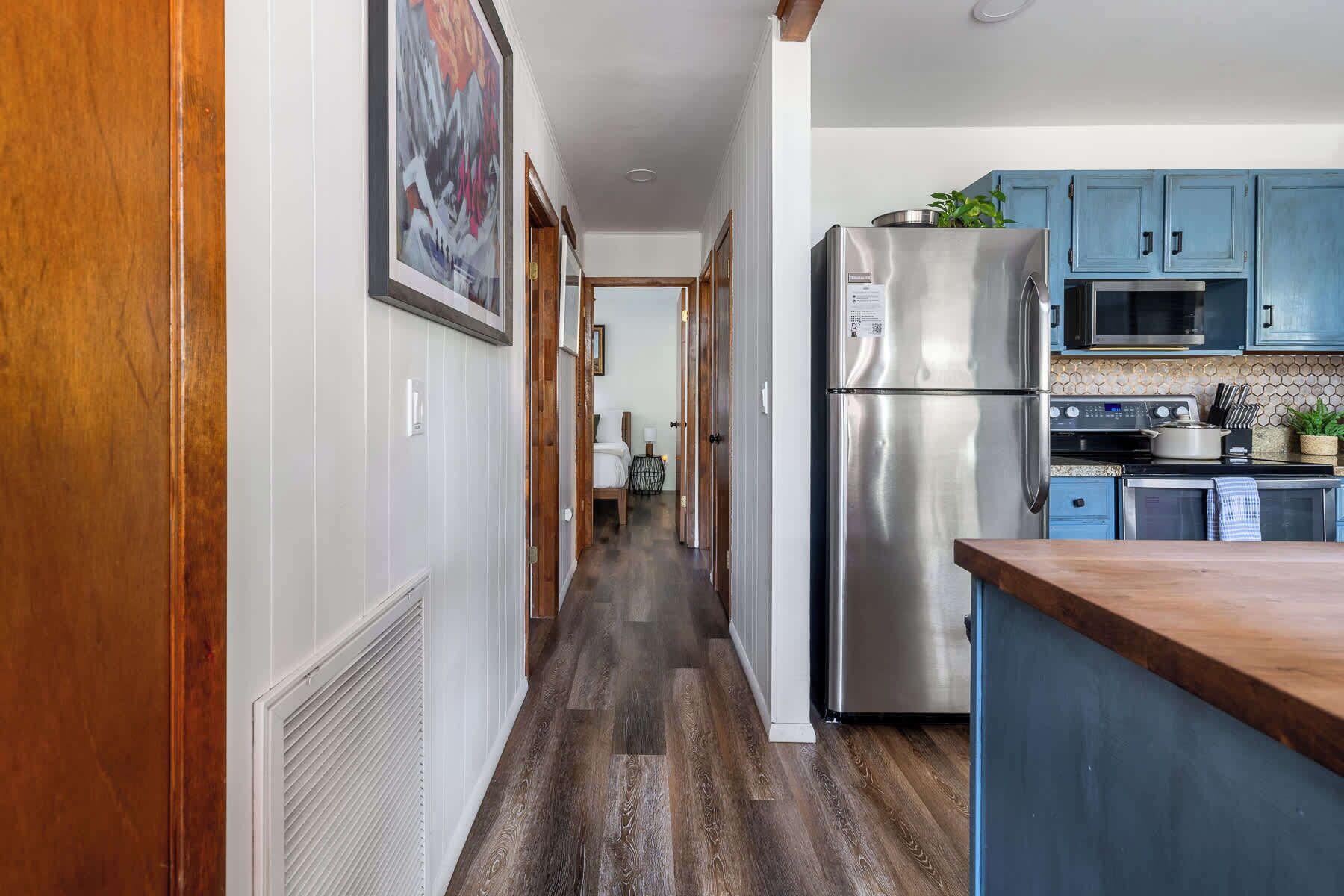 A kitchen with a stainless steel refrigerator, a microwave, and a stove.
