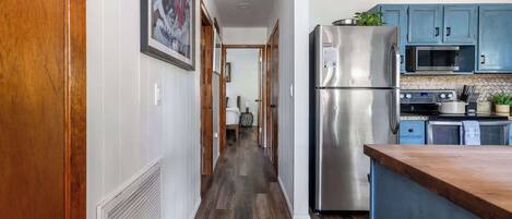 A kitchen with a stainless steel refrigerator, a microwave, and a stove.