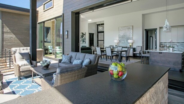 A modern outdoor living area with a dining set, a sofa, and a coffee table. - Juniper Ridge at Cordillera Valley Club (Edwards)