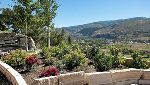 A landscaped garden with a variety of plants and a stone retaining wall. - Juniper Ridge at Cordillera Valley Club (Edwards)