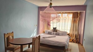 Ein Schlafzimmer mit einem Bett, einem Tisch und Stühlen.