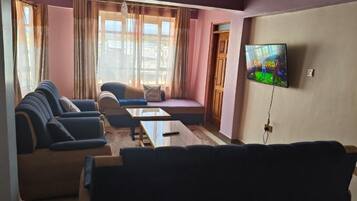 Appartement Deluxe, vue ville | Coin séjour | TV connectée de 32 pouces avec chaînes numériques