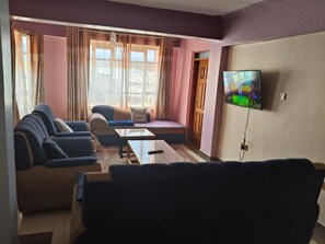 Appartement Deluxe, vue ville | Coin séjour | TV connectée de 32 pouces avec chaînes numériques