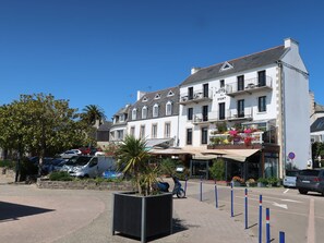 A hotel with a white facade, multiple balconies, and a sign reading "HOTEL DU PORT". - Le Clozic by Interhome (Locquirec)