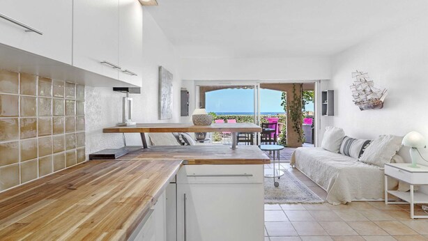 A modern kitchen with a wooden countertop, white cabinets, and a view to the outside. - APARTMENT T3 NEAR THE BEACH WITH LARGE TERRACE AND SEA VIEW FOR RENT IN STE MAXIME (STE MAXIME)