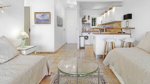 A modern apartment with a kitchen, two bedrooms, a glass table, and a view of the sea. - APARTMENT T3 NEAR THE BEACH WITH LARGE TERRACE AND SEA VIEW FOR RENT IN STE MAXIME (STE MAXIME)