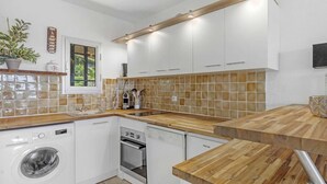A modern kitchen with white cabinetry, a wooden countertop, a washing machine, an oven, and a dishwasher. - APARTMENT T3 NEAR THE BEACH WITH LARGE TERRACE AND SEA VIEW FOR RENT IN STE MAXIME (STE MAXIME)