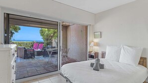 A bedroom with a bed, a nightstand, a lamp, and a view of the outdoors. - APARTMENT T3 NEAR THE BEACH WITH LARGE TERRACE AND SEA VIEW FOR RENT IN STE MAXIME (STE MAXIME)