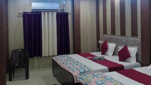 Una habitación de hotel con cama, escritorio, silla y ventilador de techo.