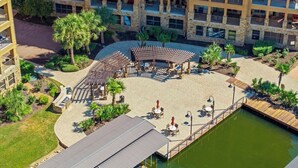 An aerial view of a hotel with a pool, outdoor seating areas, and a landscaped courtyard.