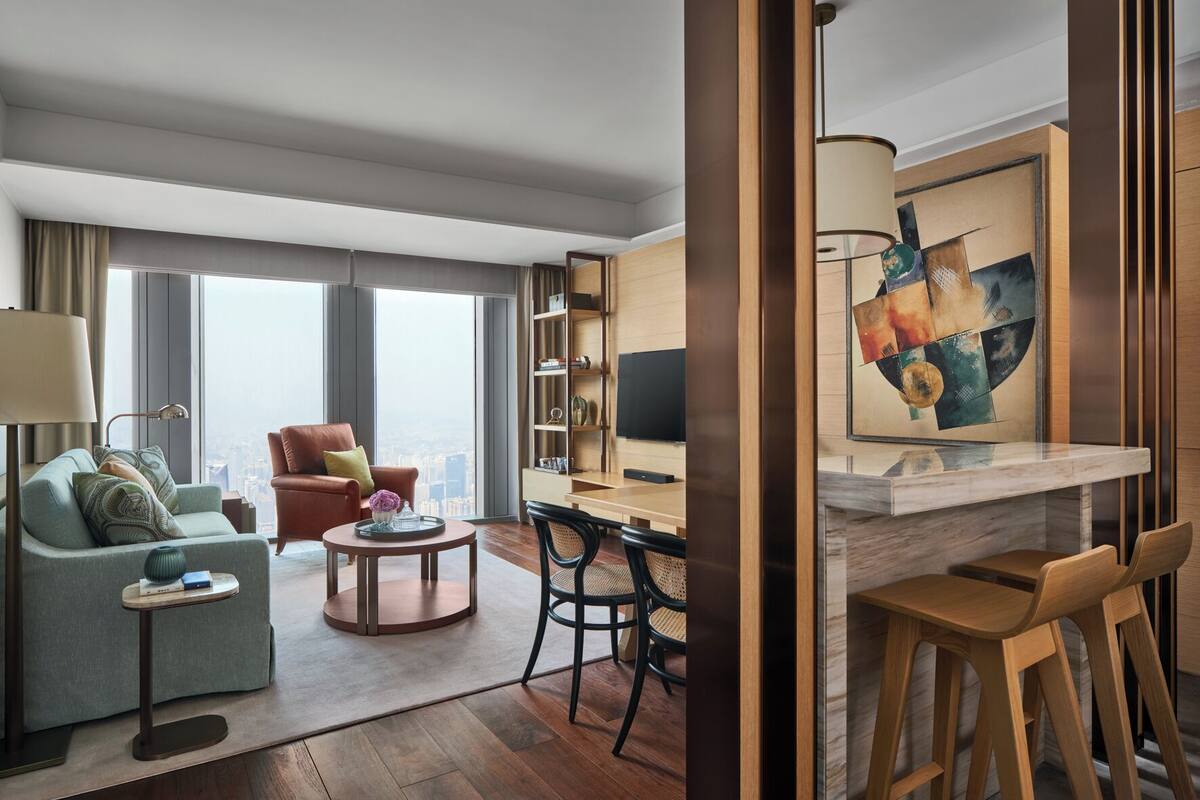 Ein modernes Hotelzimmer mit Wohnbereich, Essbereich und Küche.