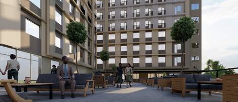 A modern outdoor lounge area with seating and a view of a high-rise building.