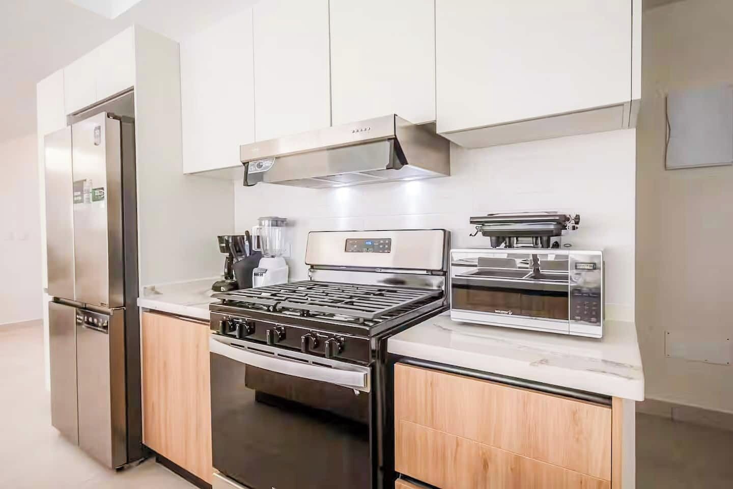 A modern kitchen with stainless steel appliances, a gas stove, and a built-in oven.