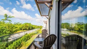 A balcony with a glass railing, two chairs, and a table. - Villa in Vistacana Private Pool Golf Beach (Punta Cana)