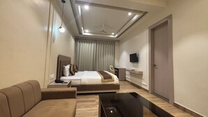 A modern hotel room with a bed, a sofa, a TV, and a desk. - Hotel Shree Rajasthan Inn (Ajmer)