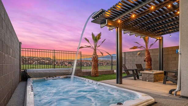 Un bain à remous avec une cascade, un espace salon extérieur et une vue sur le paysage.