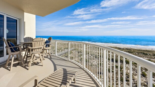 Ein Balkon mit Blick auf Strand und Meer.