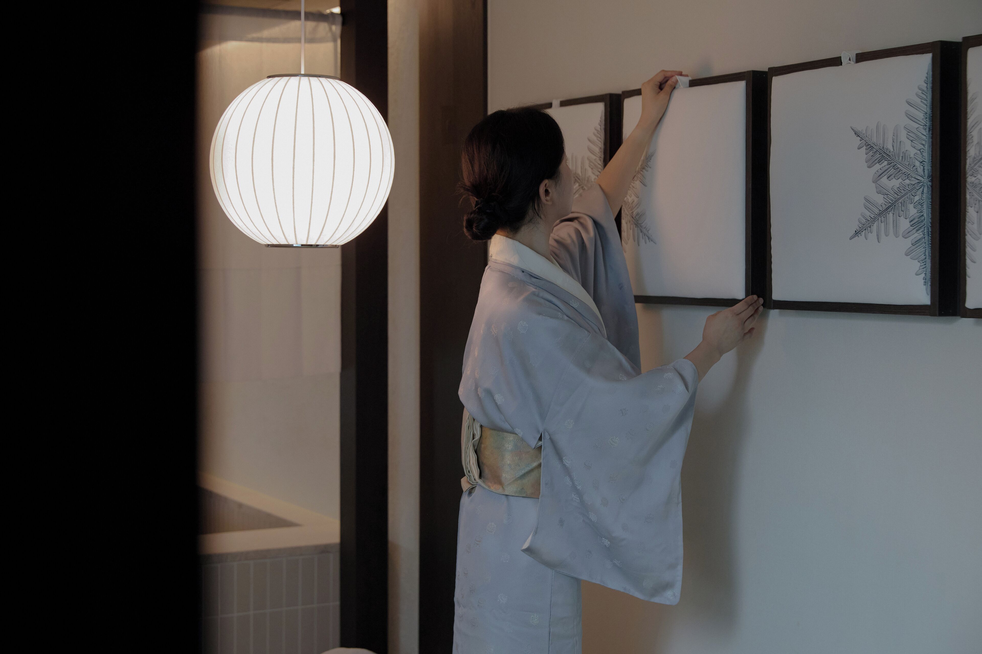 Una persona cuelga una obra de arte enmarcada en una pared.