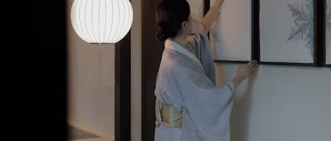 Una persona cuelga una obra de arte enmarcada en una pared.